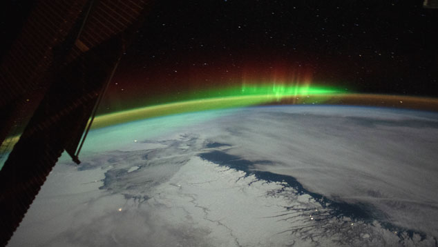 Aurora boreal surge no horizonte da Terra e  vista pelas lentes da Estao Espacial Internacional. Crdito: earthobservatory NASA